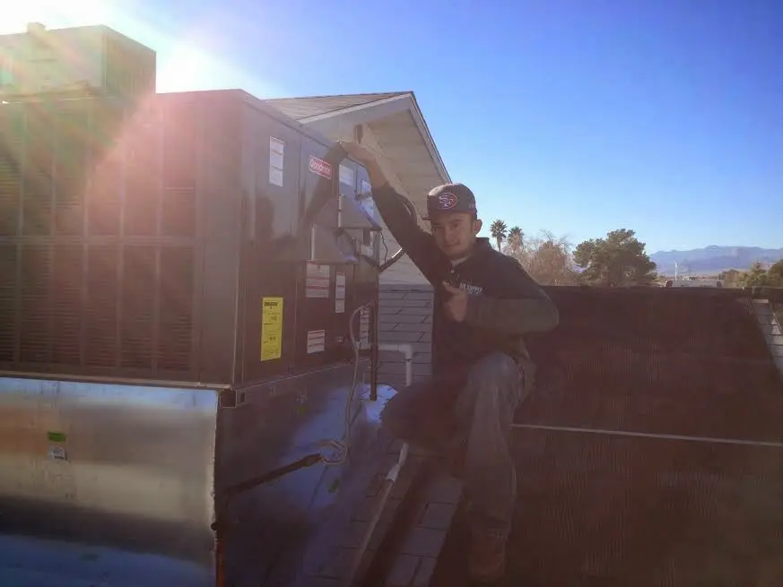 HVAC technician performing Boiler Repair on a rooftop unit in Piney Green